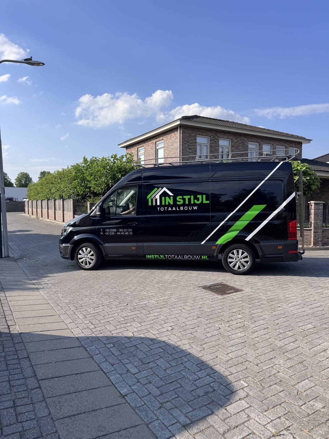 Bedrijfsbus van In Stijl Totaalbouw & Vastgoed op locatie bij een woning in Roosendaal
